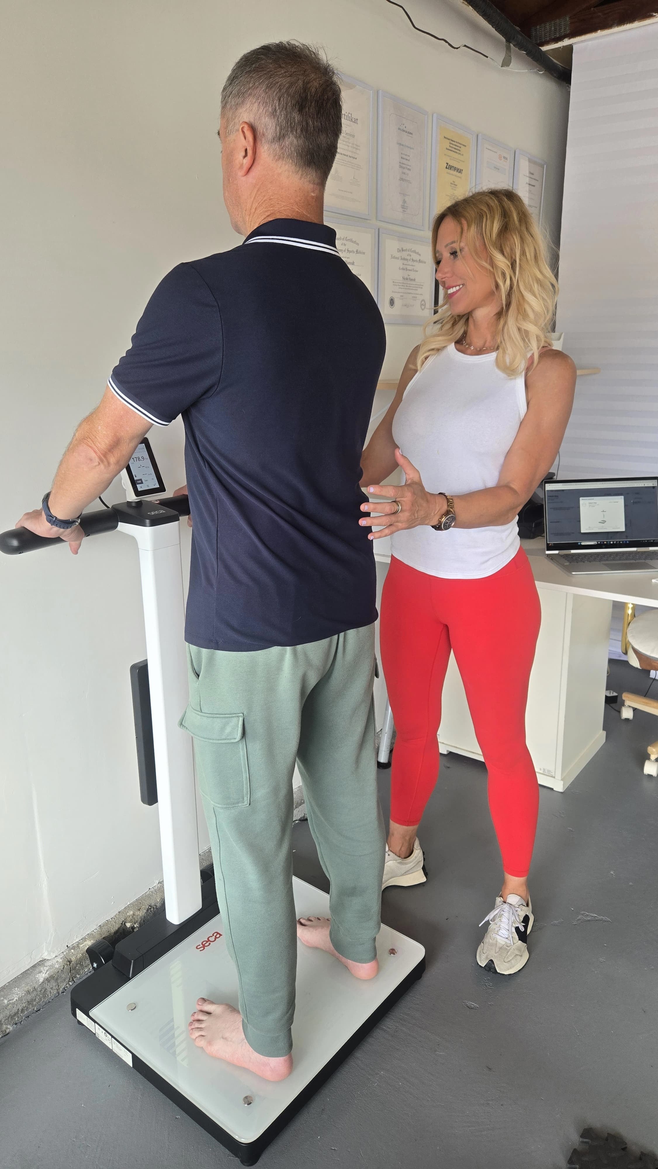 Nicole Hansult guiding a client through a Seca body composition scan during a clinical longevity evaluation in Carlsbad, CA